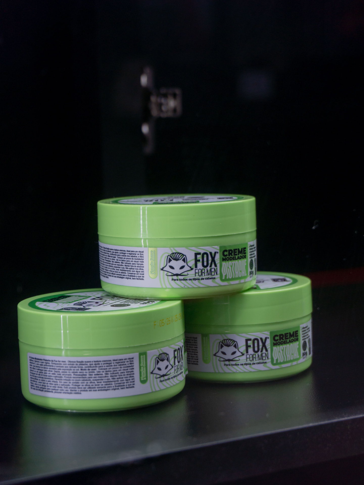 Potes de creme modelador expostos na AUX Barbearia