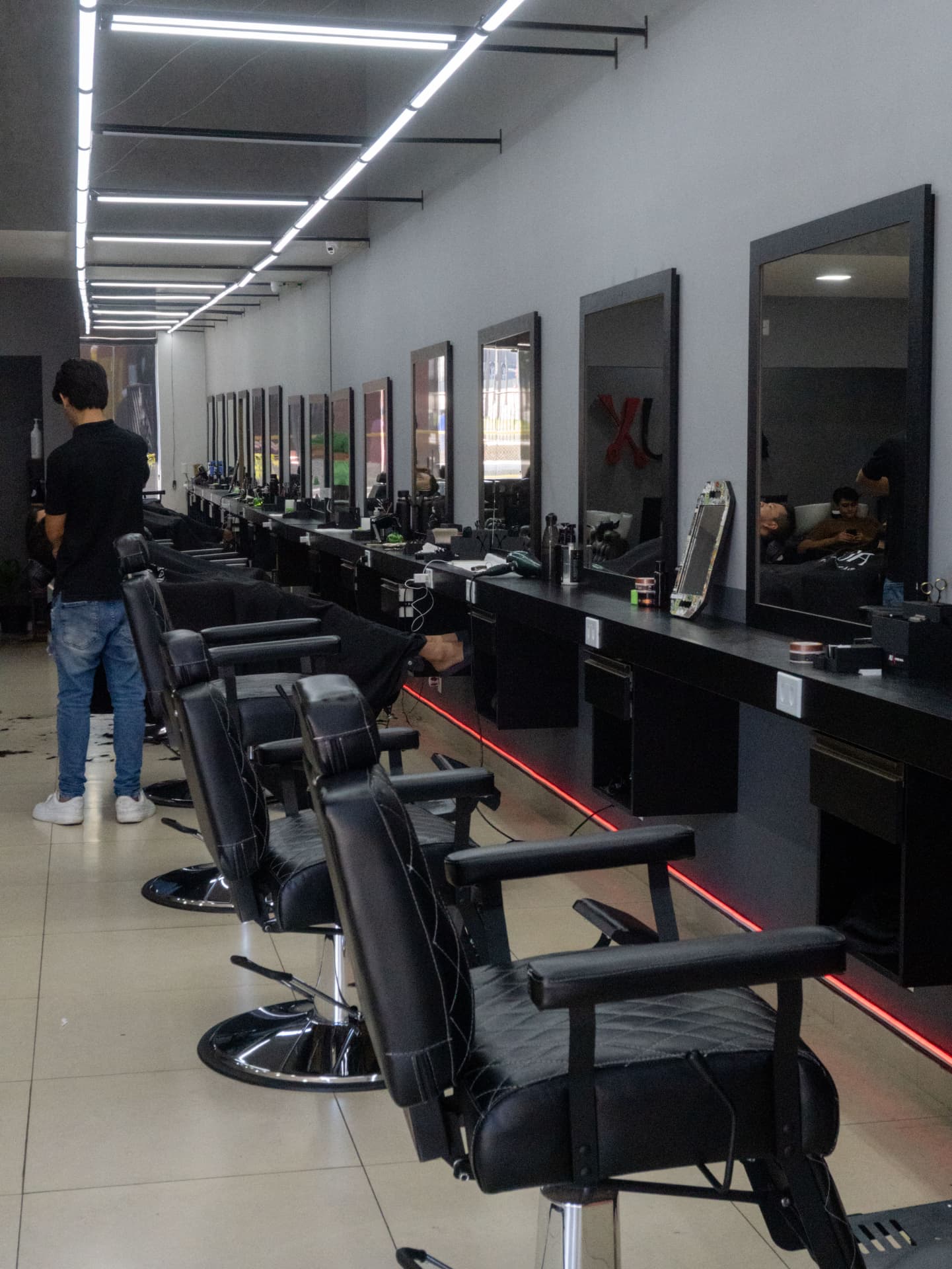 Salão da AUX Barbearia com cadeiras alinhadas e espelhos