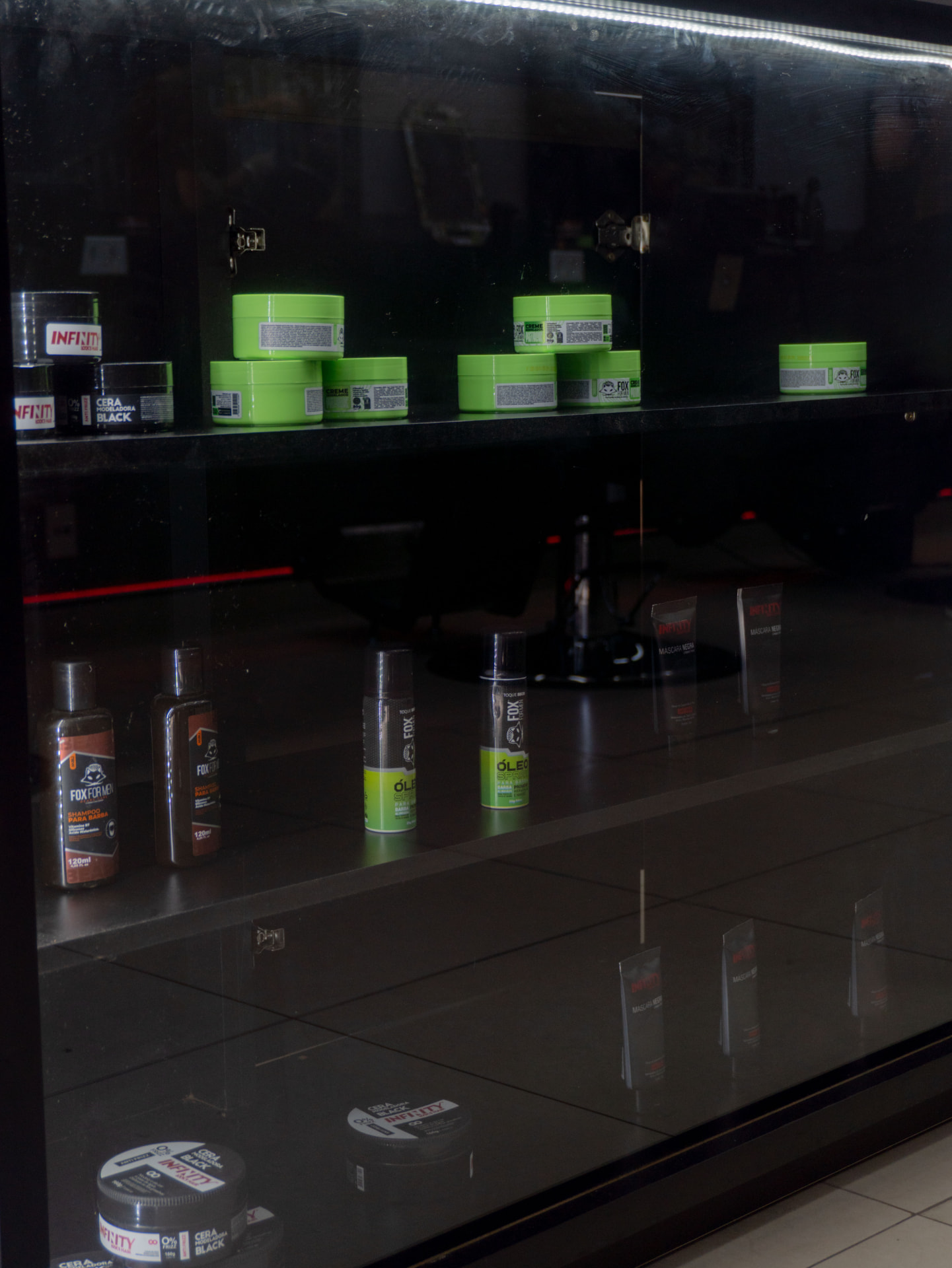 Vitrine com produtos de barba e cabelo disponíveis na AUX Barbearia